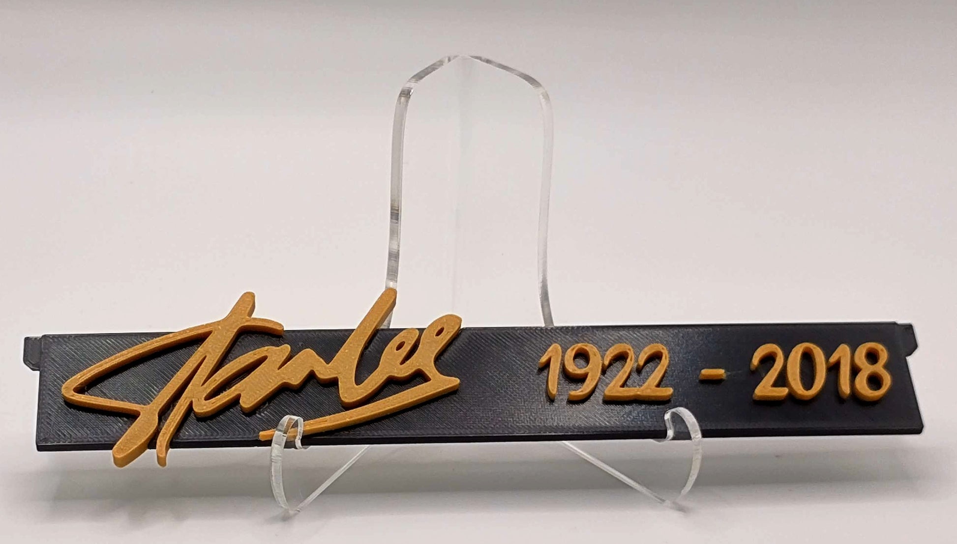Stanley logo with years 1922-2018 on a black plaque with gold text, displayed on an acrylic stand.